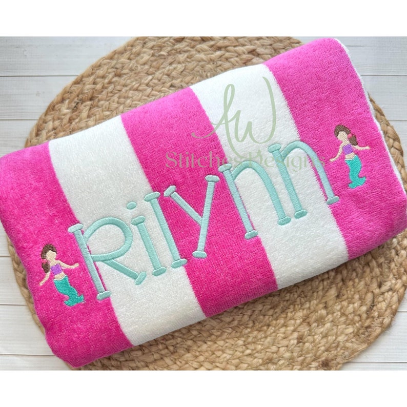 May include: Pink and white striped beach towel with the name "RiLynn" embroidered in turquoise and two mermaid figures embroidered on the towel.