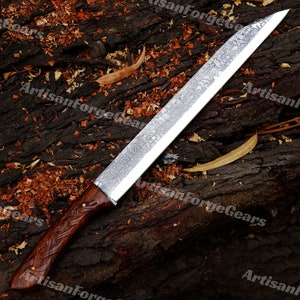 May include: A long, silver knife with a wooden handle. The blade has a hammered finish and is decorated with a pattern of runes. The handle is made of dark wood and has a braided design.