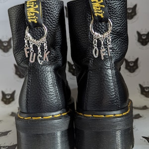 Dijes para botas de plata con la frase "F*ck off"
