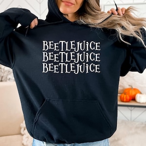 May include: Black hooded sweatshirt with the text "Beetlejuice" repeated three times in white.