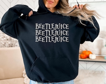 May include: Black hooded sweatshirt with the text "Beetlejuice" repeated three times in white.