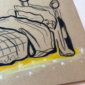May include: A sketch of a bed with a headboard and bedding. The drawing is done in black ink on tan paper, with yellow and white accents. The bed appears to be in a room, with a yellow floor and white stars.
