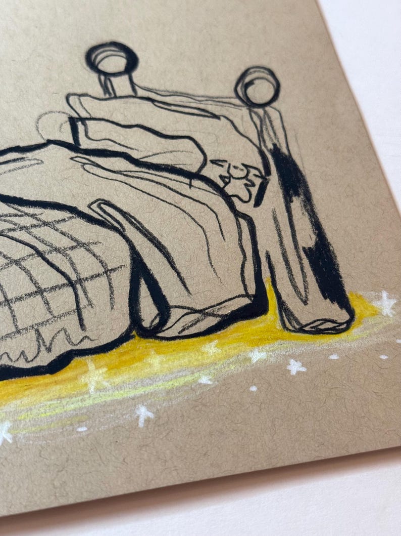 May include: A sketch of a bed with a headboard and bedding. The drawing is done in black ink on tan paper, with yellow and white accents. The bed appears to be in a room, with a yellow floor and white stars.