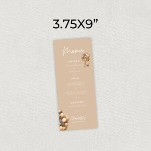 Pu&ograve; includere: Un menu marrone con la parola "Menu" in corsivo bianco. Il menu elenca "Entree", "Main" e "Dessert" con le descrizioni di ciascuno. La carta misura 3,75 x 9 pollici e presenta una piccola illustrazione di una mongolfiera fatta di perline di legno.