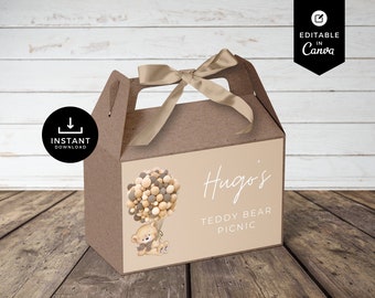 May include: A brown favour box with a teddy bear and balloons illustration. The box has a handle and a beige ribbon. The text on the box reads "Hugo's Teddy Bear Picnic".