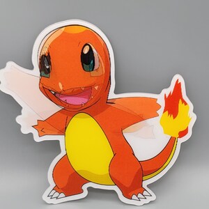 May include: A red and yellow cartoon character with a flame tail. The character has a big smile and is standing on its hind legs.