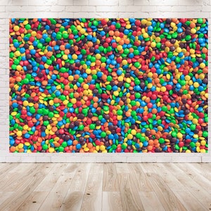 May include: A close-up image of a large collection of colorful candy coated chocolate pieces. The candies are arranged in a random pattern and are mostly red, orange, yellow, green, blue, and brown.
