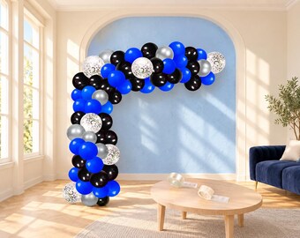 May include: A balloon arch kit featuring a collection of round balloons in solid black, vibrant blue, metallic silver, and clear balloons filled with silver confetti. The balloons are arranged in a dense, curved structure of varying sizes.
