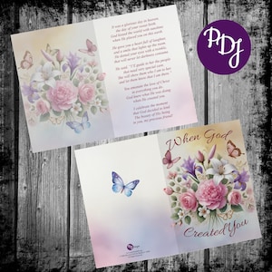May include: A greeting card with a floral design featuring pink and white flowers, green leaves, and butterflies. The card has a gold background and the text "When God Created You".