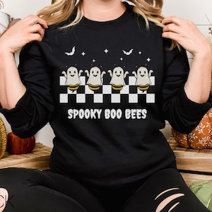 May include: Black sweatshirt with a checkerboard pattern and four ghost bees. The text "Spooky Boo Bees" is printed on the sweatshirt.