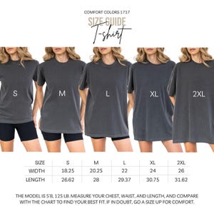 K&ouml;nnte beinhalten: Gr&ouml;&szlig;entabelle f&uuml;r Comfort Colors 1717 T-Shirts. Das Bild zeigt f&uuml;nf Models in grauen T-Shirts in den Gr&ouml;&szlig;en S, M, L, XL und 2XL. Eine Gr&ouml;&szlig;entabelle zeigt die Ma&szlig;e f&uuml;r Breite und L&auml;nge in cm. Der Text empfiehlt, Brust, Taille und L&auml;nge zu messen.