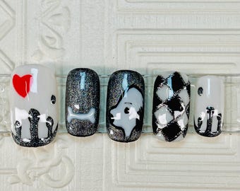 May include: Five black and white nail designs with a silver glitter accent. The designs include a heart, a bone, a dog, a checkered pattern, and a silhouette of a dog.