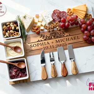 May include: A rectangular serving board featuring a white marble and wood inlay, engraved with the text SOPHIA + MICHAEL 10.11.2025 and a floral design. It includes three square white ceramic bowls with wooden spoons and four cheese knives.