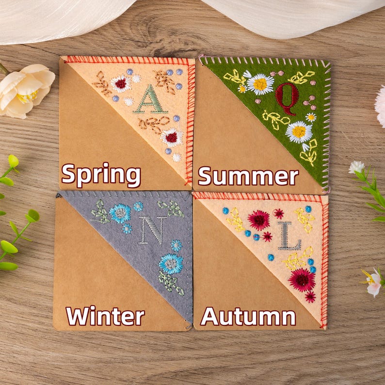 May include: Four fabric corner bookmarks with embroidered floral designs and the words "Spring", "Summer", "Autumn", and "Winter".