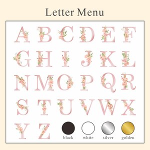 May include: A pink alphabet with floral accents, including letters A through Z.  The letters are displayed in four rows.  Below the letters are four color swatches: black, white, silver, and gold.