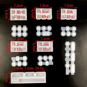 May include: A collection of clear, rectangular silicone molds for crafting. The molds vary in size and shape, with measurements in centimeters and grams. Some molds have paw prints, while others have multiple compartments. The image is on a black background.