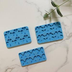 Può includere: Tre stampi in silicone blu per la creazione di oggetti in resina. Uno stampo ha sei forme di trifoglio a quattro foglie, uno ha sei forme di farfalla e l'ultimo ha dodici forme di trifoglio a quattro foglie.