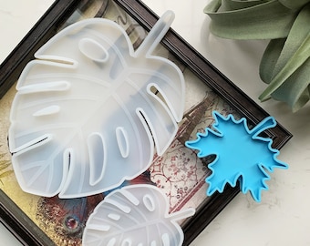 May include: Three silicone molds for resin casting, shaped like leaves. The molds are white and translucent, and the largest mold is shaped like a monstera leaf. The smaller molds are shaped like maple leaves.