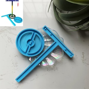 Peut inclure: Un moule en silicone bleu pour l'artisanat de la résine. Le moule est en forme de Poké Ball avec un support en forme de T.