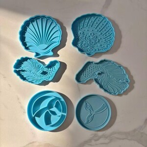 May include: Set of six blue plastic cookie cutters shaped like a seashell, a fish, and a mermaid tail.