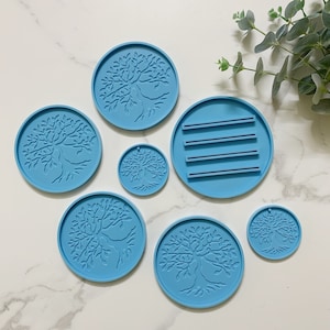 Puede incluir: Conjunto de siete moldes de silicona azul con un diseño de árbol de la vida. Los moldes son de varios tamaños y formas, incluyendo redondos, ovalados y rectangulares.