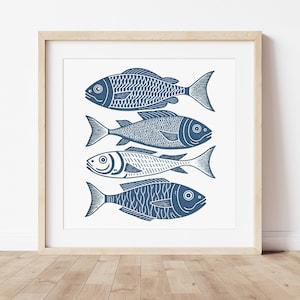 Peut inclure: Une impression encadrée de quatre poissons bleus stylisés nageant en rangée sur un fond blanc.