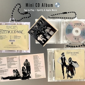 Puede incluir: Mini álbum de CD de Fleetwood Mac "Rumours". La funda de plástico transparente contiene un CD, la carátula del álbum y la letra. La carátula y el CD son visibles. La funda tiene una cadena de cuentas negras.