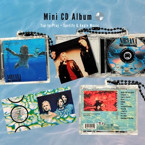 Puede incluir: Mini álbumes de CD con portadas de álbumes de Nirvana. Cada estuche de plástico transparente contiene un mini CD y la carátula del álbum. Los estuches están sujetos a una cadena de cuentas negras. El texto "Mini CD Album" y "Tap-to-Play Spotify & Apple Music" son visibles.