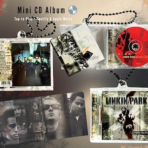Puede incluir: Mini álbum de CD con la carátula del álbum "Hybrid Theory" de Linkin Park. La funda de plástico transparente contiene un CD rojo y un folleto. El texto "Mini CD Album" y "Tap-to-Play Spotify & Apple Music" son visibles.