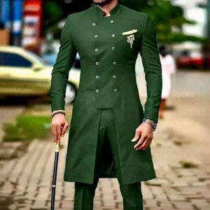 May include: A dark green suit with a double-breasted jacket and a mandarin collar. The jacket has a long, flowing style and features a decorative gold pin.