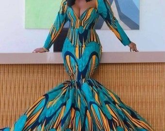 May include: A woman wearing a long-sleeved, teal, yellow and black patterned dress with a fitted bodice and a flowing mermaid skirt.