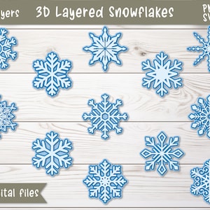 May include: Twelve digital files of blue snowflake designs, each with a 3D layered effect. The snowflakes are arranged on a white wood background. The text "3D Layered Snowflakes" and "12 digital files" are visible at the top and bottom of the image.