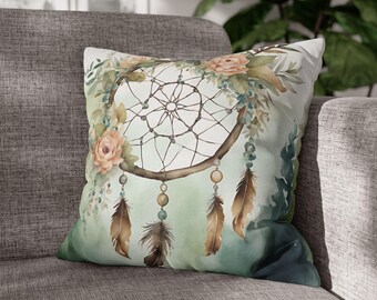 May include: A green and brown throw pillow with a watercolor design of a dreamcatcher with feathers and flowers.