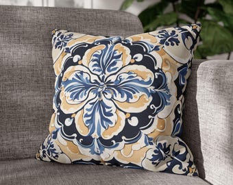 Puede incluir: Una almohada decorativa con un patrón floral azul y amarillo. La almohada tiene forma cuadrada y está hecha de una tela suave.