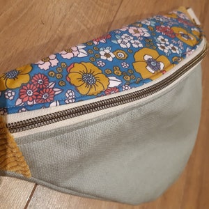 Bum bag in pastel water green coated linen and coated floral flap, yellow velvet fabric at the ends.