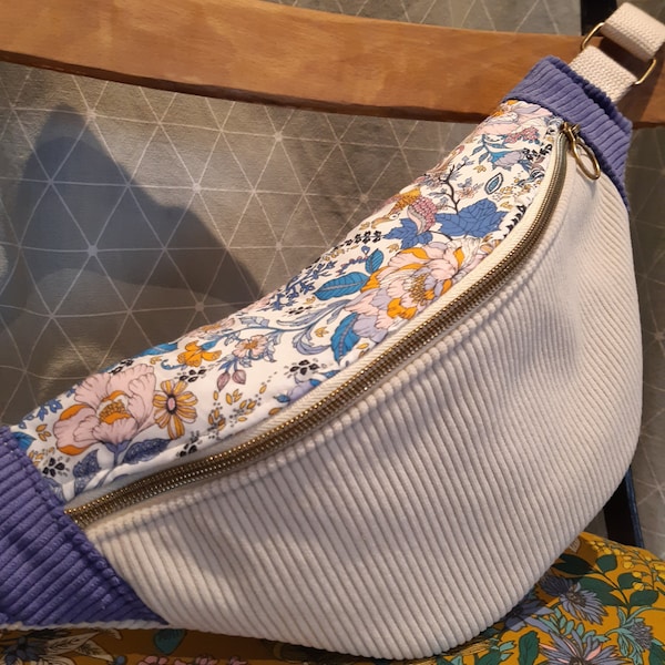 Sac banane en velours côtelé beige,rabat fleurs bleues et motifs orangés et roses pâles et côtés en velours violet.