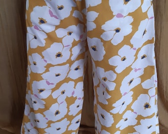 Pantalón fluido con flores blancas y tejido amarillo, elástico rosa a juego