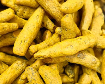 May include: Close-up shot of fresh, vibrant yellow turmeric roots. The image showcases the textured, irregular shapes of the turmeric, highlighting its natural form. The bright yellow color dominates the frame, suggesting a focus on culinary or health applications.