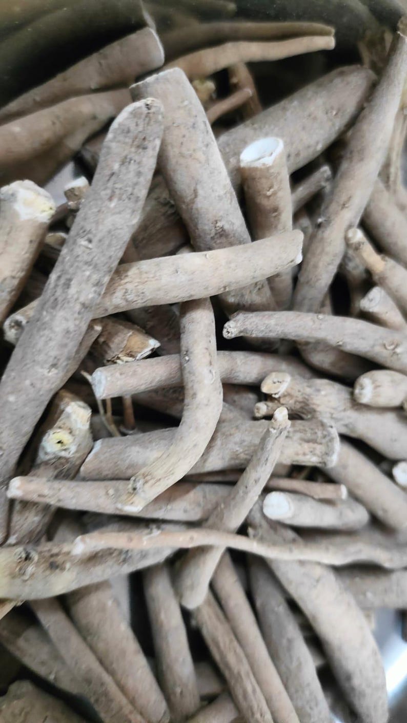 May include: Close-up of a pile of light brown, irregularly shaped wooden sticks. The sticks vary in size and thickness, with some showing cut ends. The overall texture appears rough and natural.