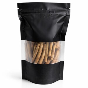 May include: A black, stand-up pouch with a clear window displaying a collection of brown, stick-like items. The pouch has a zip-top closure and a white background.