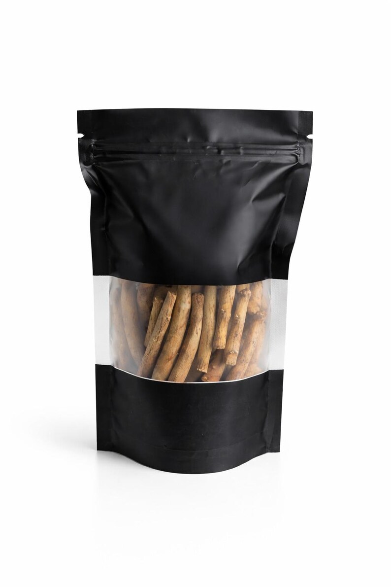 May include: A black, stand-up pouch with a clear window displaying a collection of brown, stick-like items. The pouch has a zip-top closure and a white background.