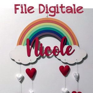 Puede incluir: Un recorte de madera de arcoíris con una nube blanca y el nombre "Nicole" en rojo. Colgando de la nube hay corazones de fieltro rojo y blanco.