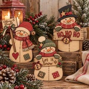 May include: Three wooden snowman ornaments with painted details. One holds a sign reading Merry & Bright, one holds a sign reading HO HO HO, and one holds a sign reading Let it Snow. Each snowman wears a hat and scarf with jingle bells.