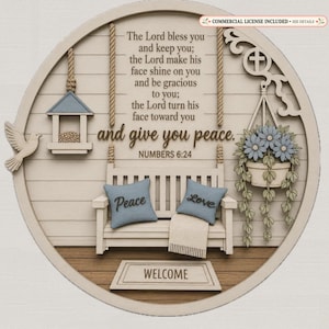 May include: A circular wooden wall sign featuring a porch scene with a bench, a bird feeder, and a hanging flower basket. The text reads: The Lord bless you and keep you; the Lord make his face shine on you and be gracious to you; the Lord turn his face toward you and give you peace. NUMBERS 6:24. A welcome mat is at the base.