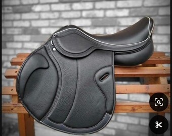 May include: A black leather saddle with white stitching and a dark blue trim. The saddle is designed for horseback riding.