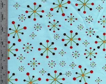 May include: Light blue fabric with a repeating pattern of stylized starbursts in red, brown, and orange, connected by green lines. The smaller starbursts are brown and red. The fabric has a ruler along the left edge.