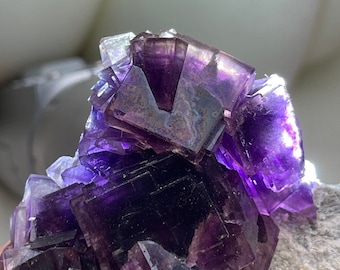 Amostra de fluorita roxa com cristal de iridescência natural
