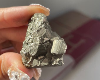 May include: A raw, metallic, gray pyrite crystal with a rough, textured surface. The crystal has a natural, irregular shape and is a popular choice for crystal healing and decorative purposes.