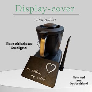 Può includere: Un elettrodomestico da cucina nero con manico argentato e tagliere nero con la scritta "My kitchen... my rules!" con un simbolo a cuore. L'immagine include anche un utensile nero e il testo "Display-cover" e "SHOP ONLINE".