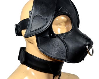 May include: Black leather dog-style mask with large ears and a nose ring. The mask covers the eyes and nose, with a matching collar. The ears have heart-shaped details. The collar has a metal ring.